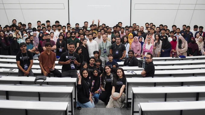 A large group gathers in a lecture hall.